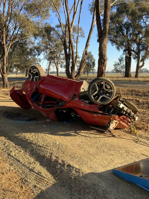 The driver of this red Commodore was taken to a Canberra hospital after a crash early on Sunday.