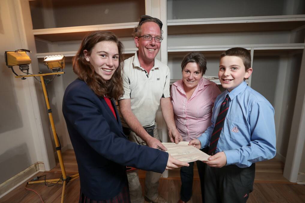DISCOVERY: Builder Fran Buxton (middle) found a government declaration from the 1950s belonging to a previous owner in the walls of the Diver family's West Albury home. Alana, 16, mum Joanne, and Murray, 11, will now place their own piece of history with the old document in the walls of their renovated home. Picture: JAMES WILTSHIRE