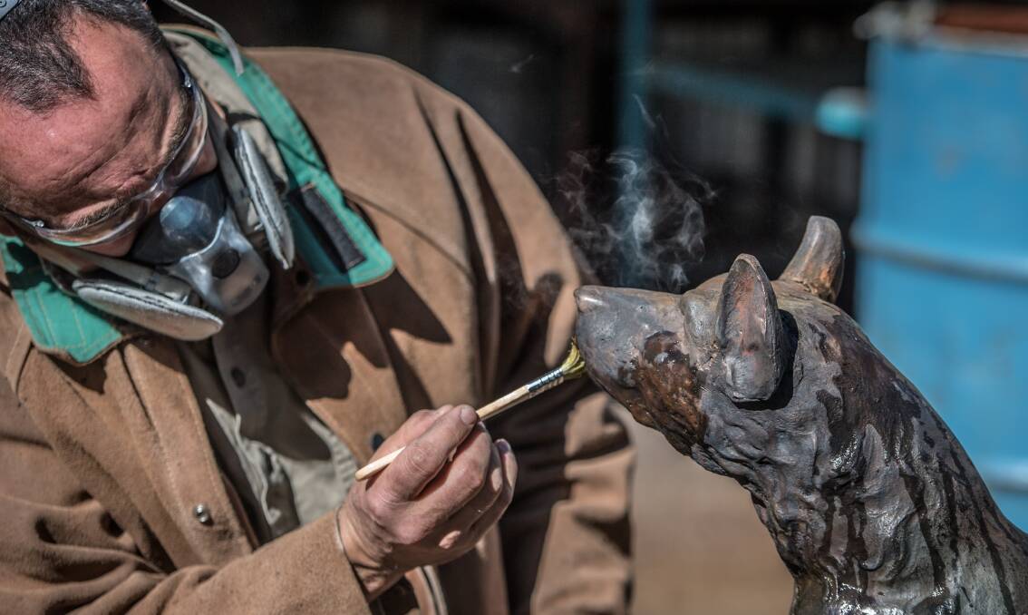ANU School of Art lecturer and foundry expert Nick Stranks applies a chemical restorative to the vandalised 'Dog on the Tuckerbox'. Picture: Karleen Minney