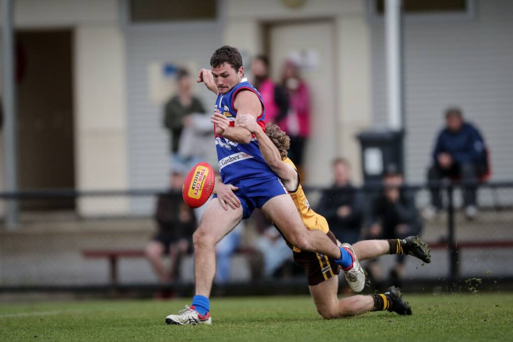 STRENGTH: Thurgoona's Blair Wallace gets his kick away as Kiewa's Ryan Wallace lays a tackle. The Bulldogs proved too strong in the end. Picture: JAMES WILTSHIRE