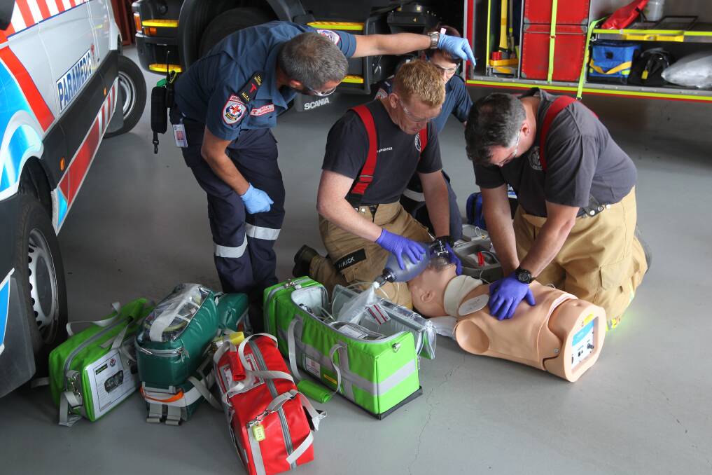 WORKING AS ONE: Aided by ambulance officer Paul Reynolds, CFA firefighters Mark Strack and John Macklin demonstrate their EMR training.