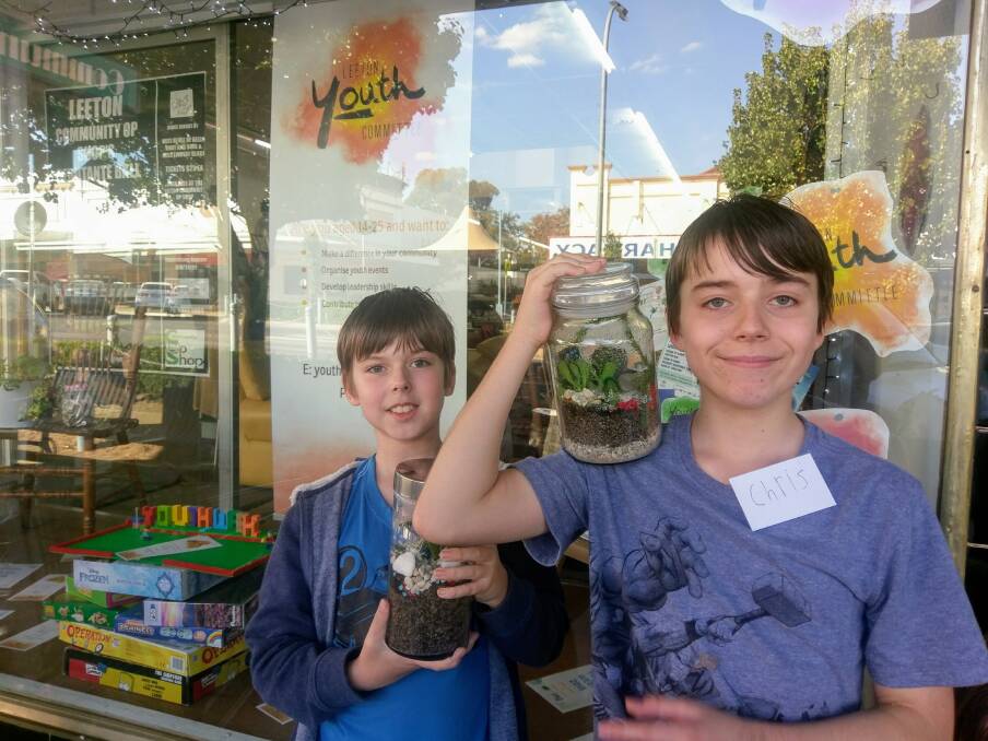 "WORKSHOP": Laurelle Lewis homeschools her children, Noah Forbes (left) and Chris Forbes, who are showing off their jar environments from a community workshop. Photo: supplied. 
