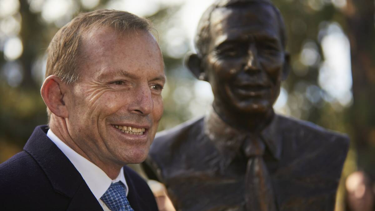 Tony Abbott poses beside his bust. 