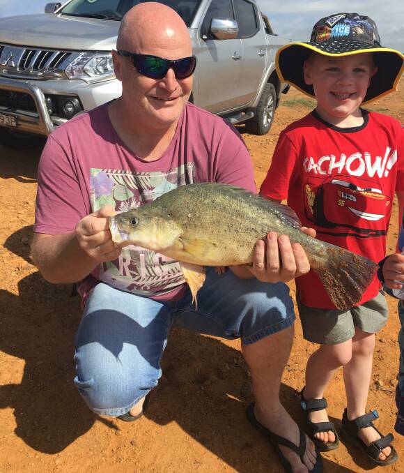 GOOD DAY: Reader Bobby Dazzler caught his first yellowbelly while fishing off the bank at Hume Weir during a recent fishing expedition with young Boston, 5.