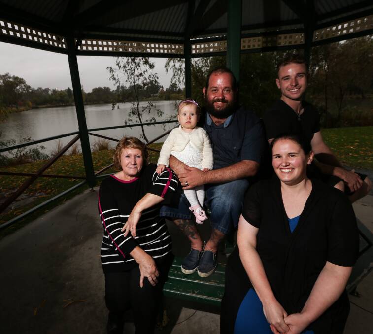 SHELTER: Jenny Lepoidevin, Olivia, 1, Daniel and Charlene Evans and Adam Beswick escape the rain.