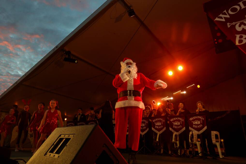 SPECIAL GUEST: Santa Claus was a popular attendee at Wodonga's Carols by Candlelight event in Willow Park last night. Pictures: TARA TREWHELLA