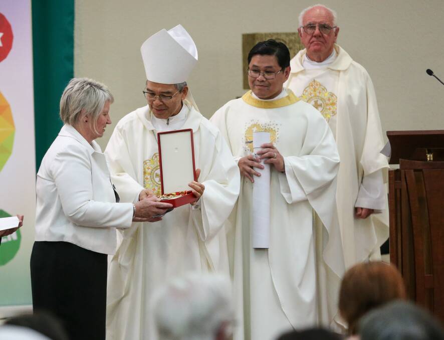 HONOUR: Judy Brewer accepts the Order of St Gregory The Great bestowed on her late husband.