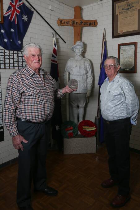 SEARCH IS ON: Wodonga RSL president Jim Begley and past president Kevyn Williams with the plaque belonging to the Gordon family. Picture: TARA TREWHELLA