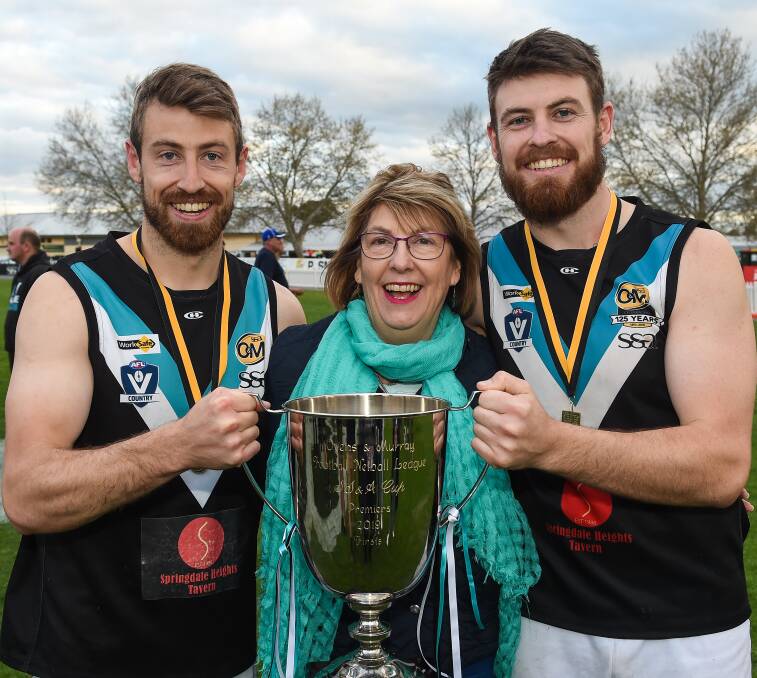 FAMILY AFFAIR: Sam and Tom Hargreave share the premiership spoils with mum Deb after the Lavington grand final victory.