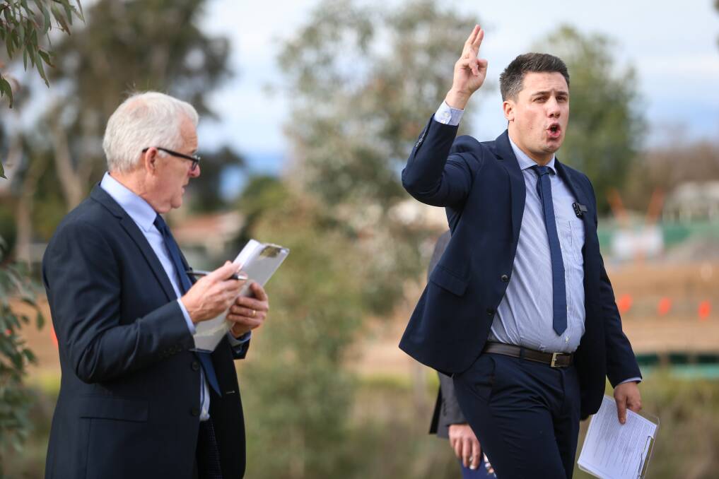 GOING, GOING, GONE: PJ Murphy Real Estate auctioneer Leon Kowski, right, and Pat Murphy at the Wodonga golf course where five blocks sold under the hammer. Picture: JAMES WILTSHIRE