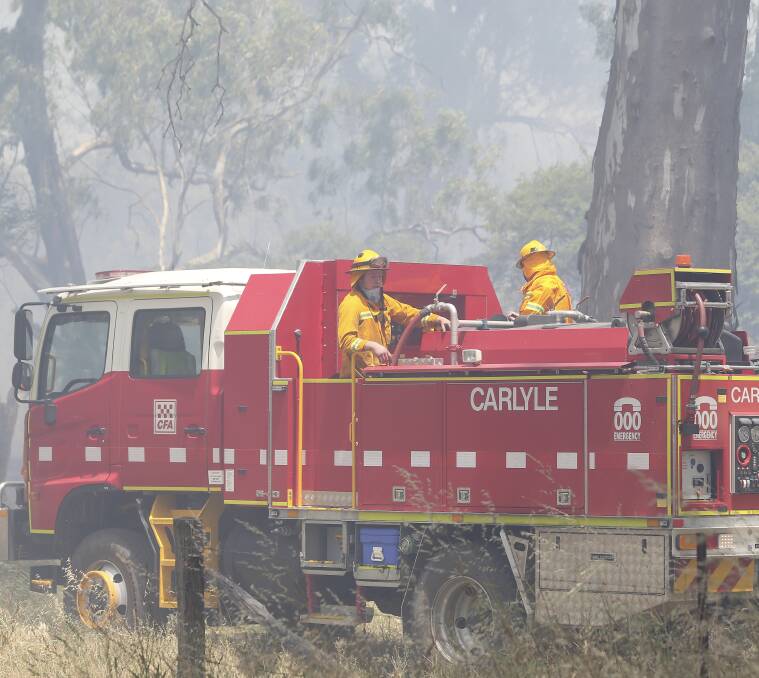 THICK SMOKE: CFA firefighter head in to stop the spread of flames. Pictures: ELENOR TEDENBORG