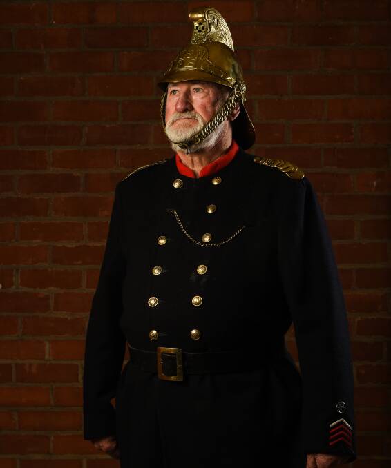 LONG SERVICE: Former Albury Civic Fire Brigade captain Harold Byrnes in his brass helmet and old uniform. Picture: MARK JESSER