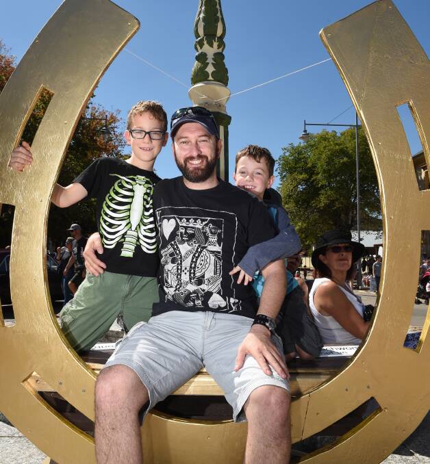 GOLDEN EASTER: Ryan Walch jumped in the golden horseshoe, with his children Will, 7, and Thomas, 6, from Table Top at Beechworth. Picture: MARK JESSER