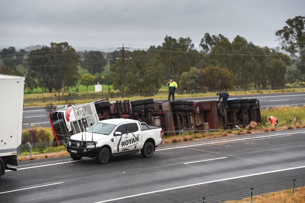 TRUCK ROLLOVER: Emergency service workers remain on the scene. Picture: MARK JESSER