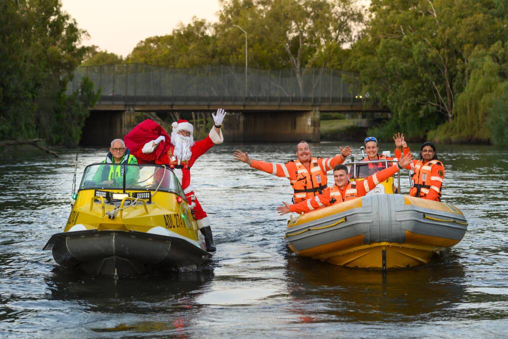 ON THE WAY: Santa, on an Albury and Border Rescue Squad boat, is escorted down the Murray by the NSW SES Albury Unit. Picture: MARK JESSER