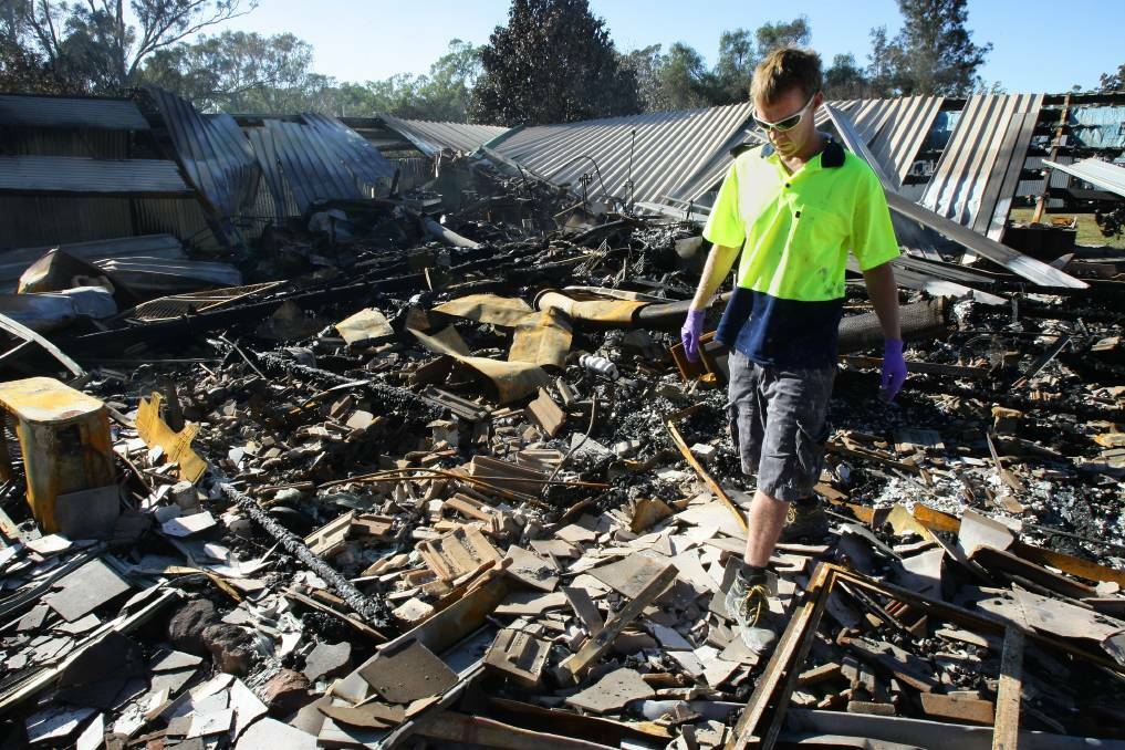 DESTROYED: Sharon's brother, Darryl Purdy, sifts through the rubble of his sister's home in the days following the horrifying 2009 blaze. Picture: JOHN RUSSELL