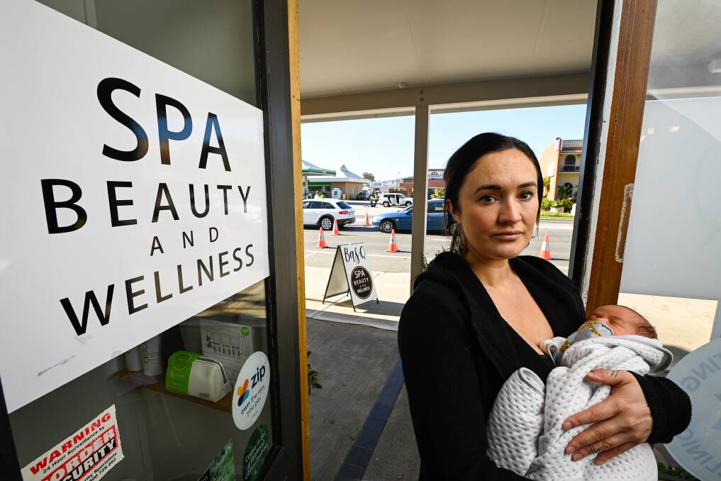 CHECKPOINT: Basq Beauty Spa and Wellness owner Courtney Callesen, with her two-week-old son Buddy Corrigan, said she knew the border checkpoint would be close to their front door but didn't expect the business to be completely hidden by the police operation. Pictures: MARK JESSER