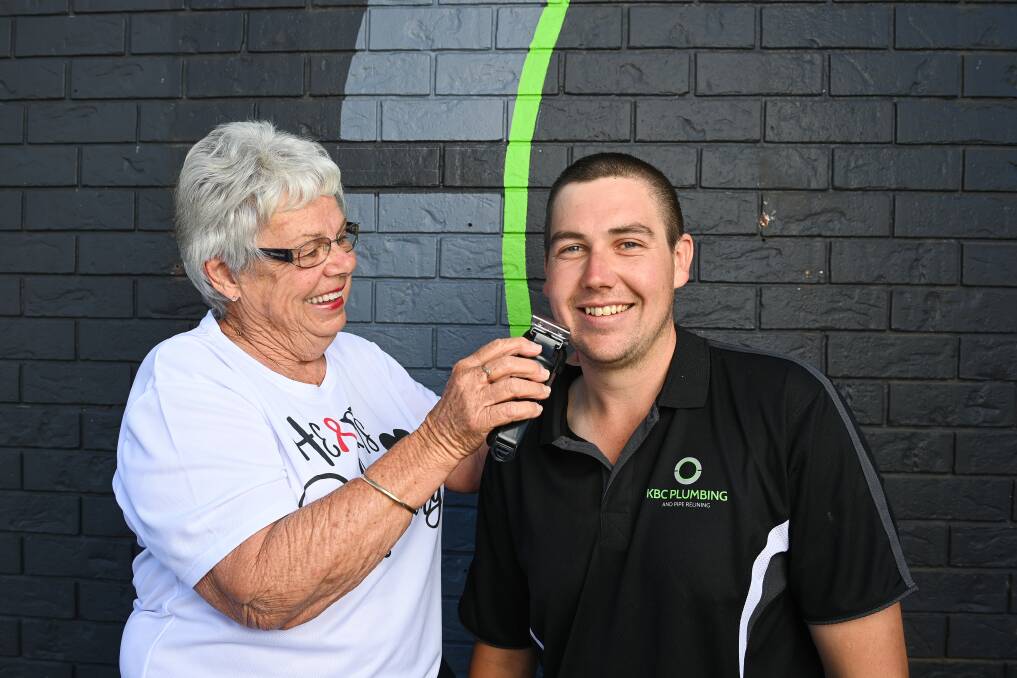 FAMILY: Marie Orr helps grandson Mitch Orr shave his head as part of fundraising for the Sunshine Walk. Picture: MARK JESSER
