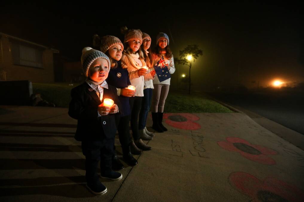 FROM HOME: The Poulton family stood on their driveway for the dawn service. Pictured is Leo, 1, Freya, 4, Gemma, 6, Sophie, 8, and Jasmine, 9. Picture: JAMES WILTSHIRE