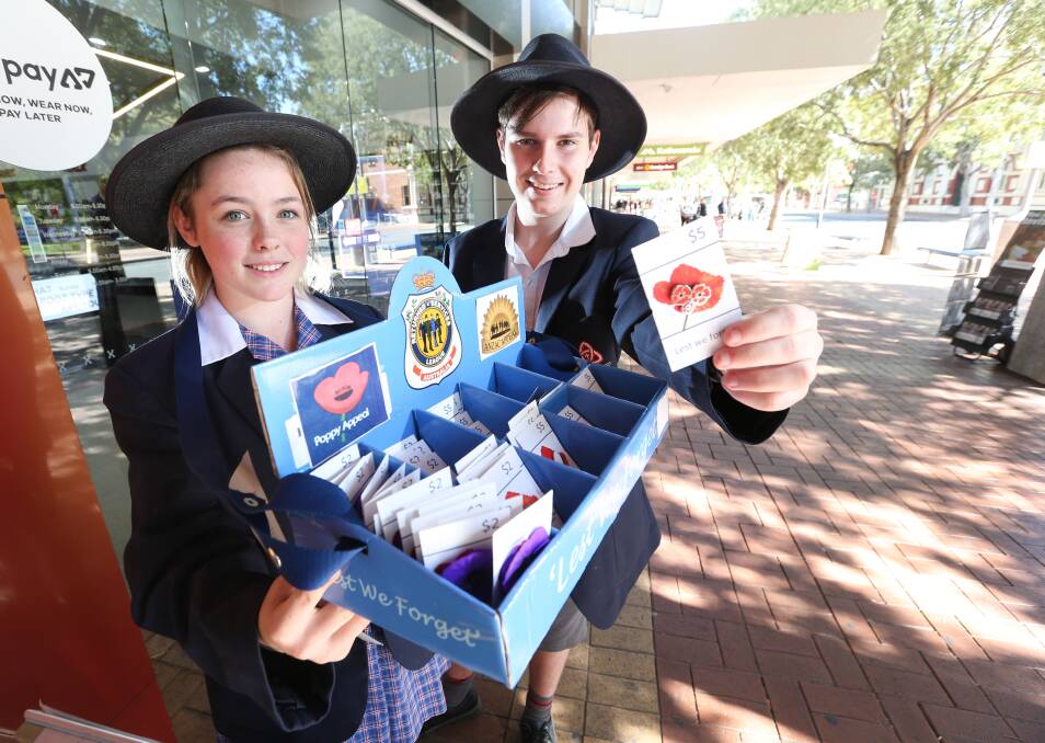 VOLUNTEERING: Trinity Anglican College students Shannyn Leskie and Damon Phegan were on Dean Street today selling Anzac Day badges. Picture: KYLIE ESLER