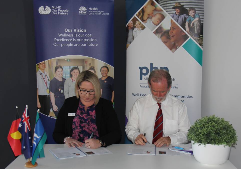 Murrumbidgee Primary Health Network Chief Executive Officer Melissa Neal and Murrumbidgee Local Health District Acting Chief Executive, Maurice Ahern sign the Murrumbidgee Maternal and Child Health Strategy.
