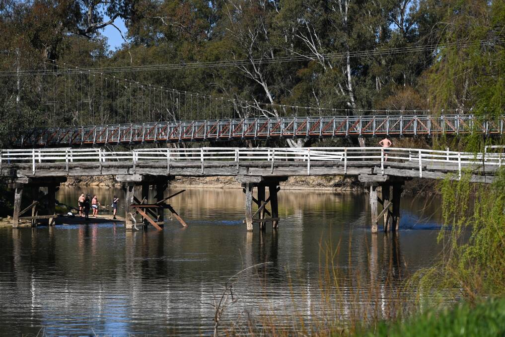 RIVER DANGERS: Young men jump from a bridge over the Murray River. Picture: MARK JESSER