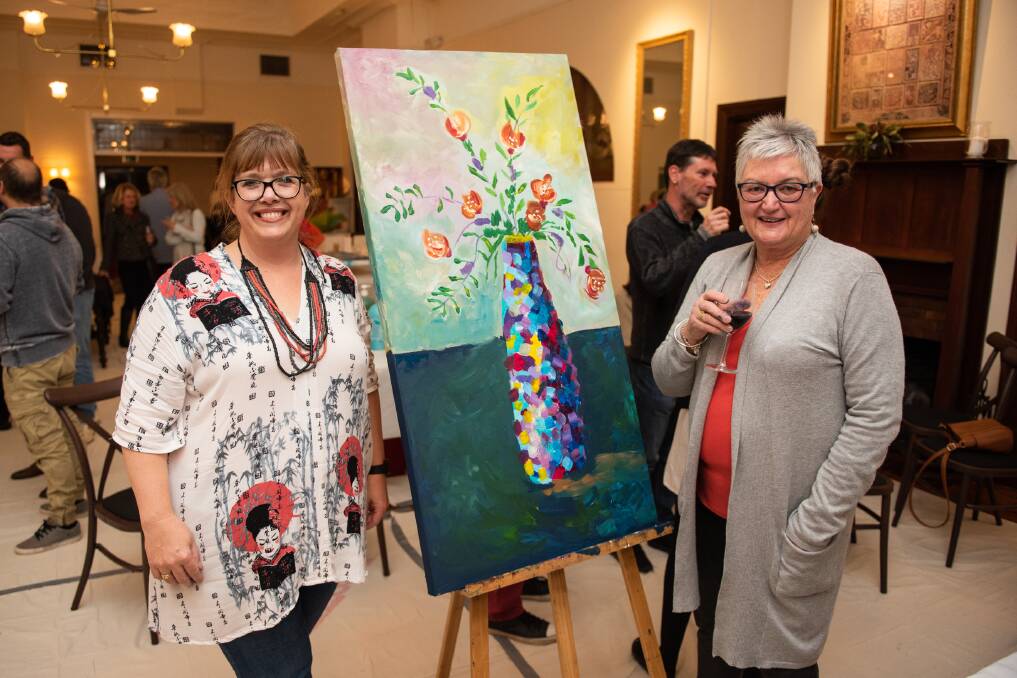 FINISHED PRODUCT: Melissa Thomas and Julie Morgan with one of the paintings that were auctioned off. Picture: LUKE HUNTER MEDIA