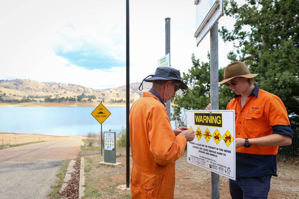 WARNING: WaterNSW workers install warning signs at a Lake Hume boat ramp after the blue-green algae red alert was issued on Monday. Picture: JAMES WILTSHIRE