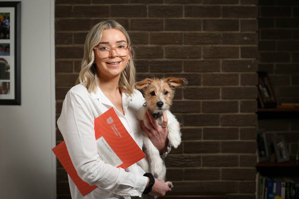 GRAD AT HOME: Charles Sturt University graduate Kate McKee, pictured with dog Jordy, was one of thousands who missed out on the traditional graduation ceremony. Picture: JAMES WILTSHIRE