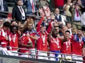 Nottingham Forest's Joe Worrall, centre, lifts the trophy and celebrates promotion.