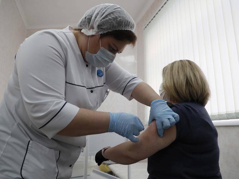 A medic innoculates a patient with Russia's new COVID-19 vaccine at a clinic in Moscow.
