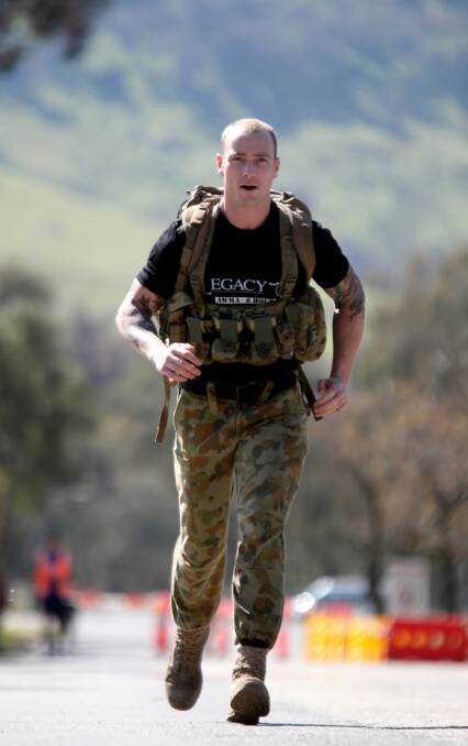 Cerberus Physical Training School Army Corporal Ben Nott lugs a 32-kilogram pack on his leg of the Legacy relay. Picture: PETER MERKESTEYN