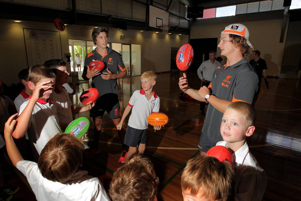 King of the kids ... Caleb Marchbank and Sam Schulz at Trinity College in Thurgoona yesterday. Marchbank and Culcairn’s Schulz visited several schools and the Albury hospital yesterday as part the AFL Community Camp program. Players are also spending time in Canberra, Wagga, Griffith, Bathurst, Orange, Dubbo, Broken Hill and on the South Coast. Picture: DAVID thorpe