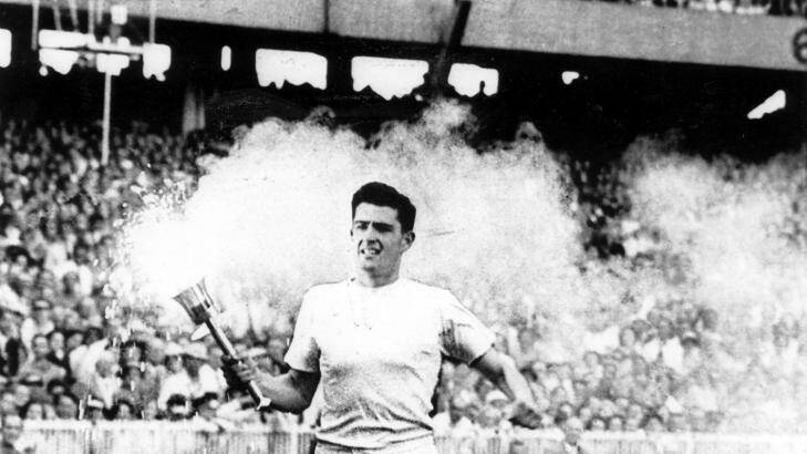 Ron Clarke carries the torch / flame around the MCG during the opening ceremony, 1956. Photo: Fairfax Archives