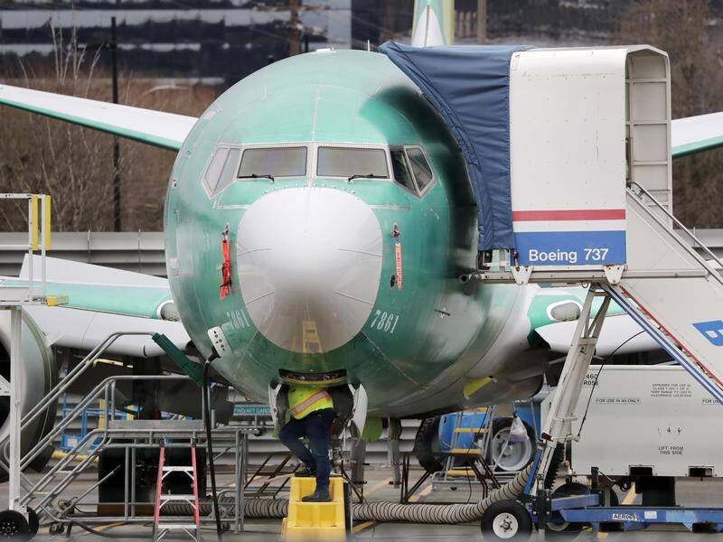 Boeing says it will halt production of its beleaguered 737 MAX jet in January.