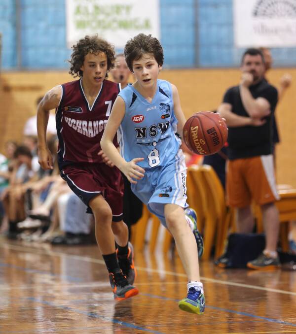 Lachlan Damir, 12, makes a break for NSW with Marcus Herbert, 12, of the Victorian Bushrangers, in hot pursuit. Pictures: JOHN RUSSELL