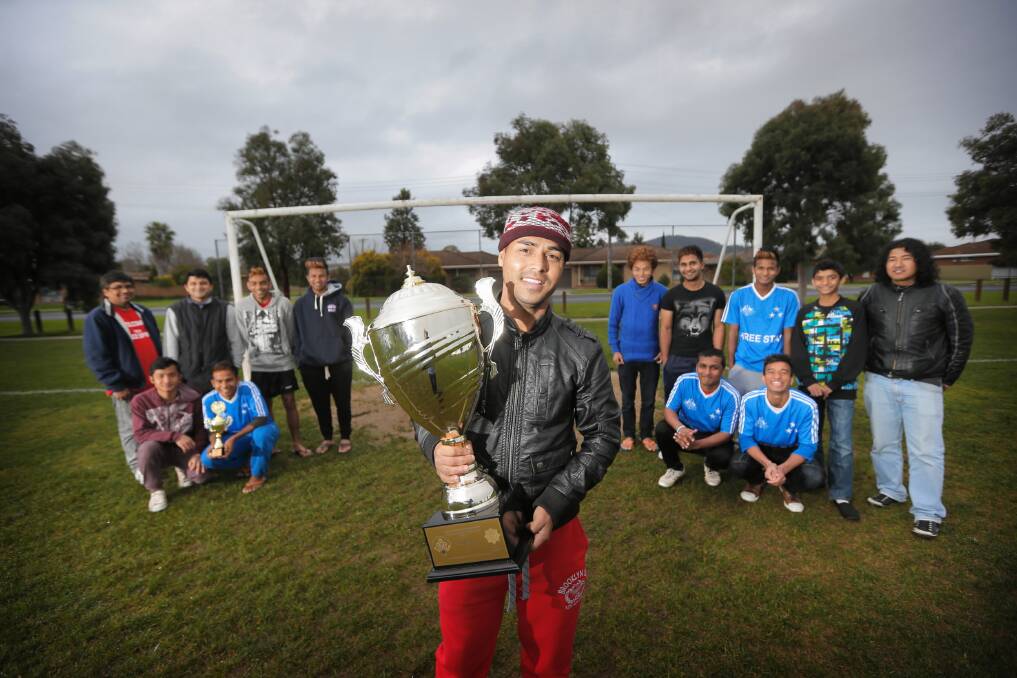 The Albury-Wodonga Bhutanese soccer team, Three Star, won the Australian Bhutanese Youth Festival’s third interstate tournament in Sydney and are bidding to host the next cup. Captain Mon Chhetri, centre, with the winning cup, is surrounded by his teammates. Picture: TARA GOONAN