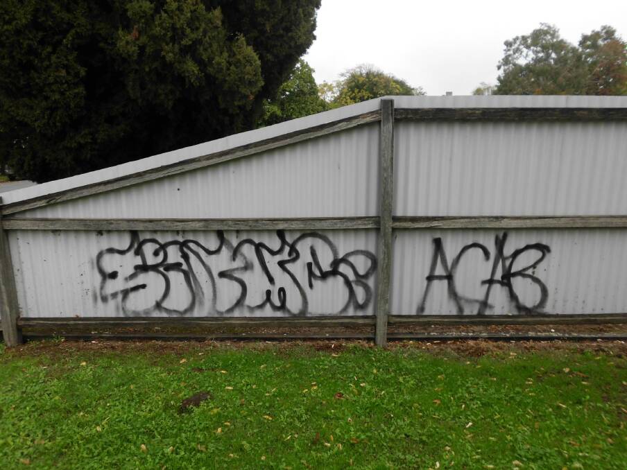The graffiti written across a fence at the side of Beechworth’s police station.