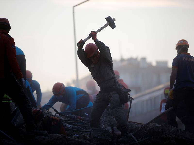 Rescuers work to find any survivors after a strong quake struck the Turkish coastal city of Izmir.