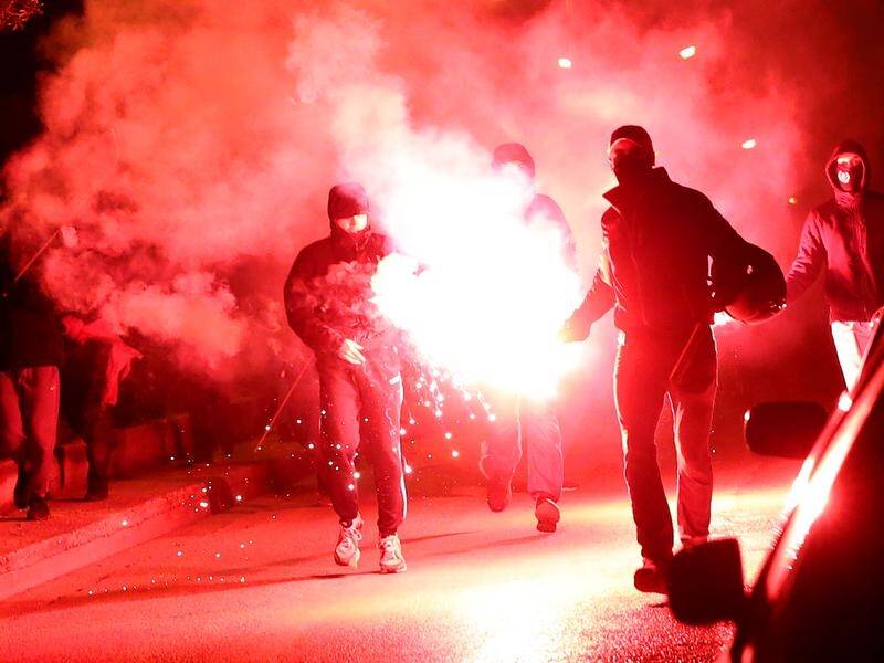 A protest over police violence in Athens has turned into a riot in which five officers were injured.