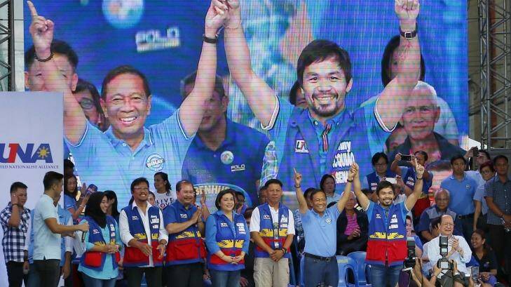 Philippine Vice President and now opposition presidential candidate Jejomar Binay, second from right, raises the hands of senatorial candidate, boxer and Congressman Manny Pacquiao, right, who is widely popular in his home country. Photo: Bullit Marquez
