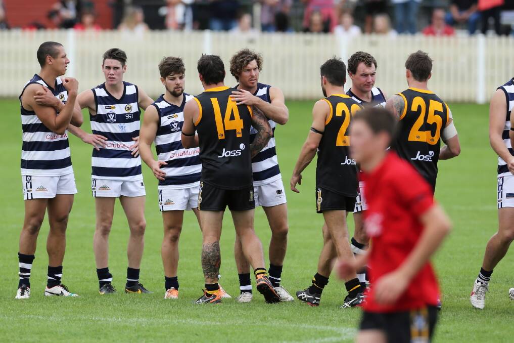 Players from Albury and Yarrawonga shake hands after the match was called off early. Pictures: MATTHEW SMITHWICK
