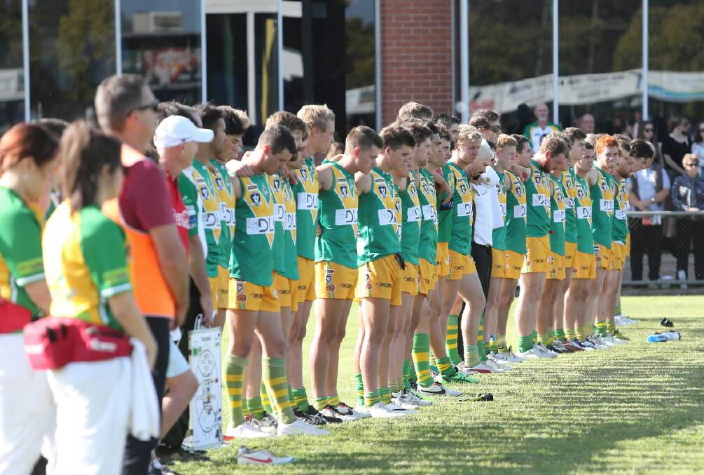 The North Albury players observe a minute’s silence ahead of their Anzac Day clash.