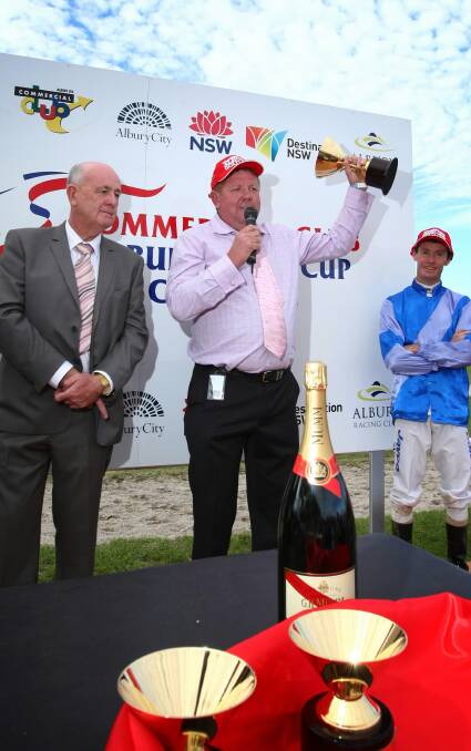 Brett Cavanough accepts last year’s Albury Gold Cup from Commercial Club president Barry Edmunds after jockey Mathew Cahill rode Niblick to victory. Niblick will defend his title tomorrow.
