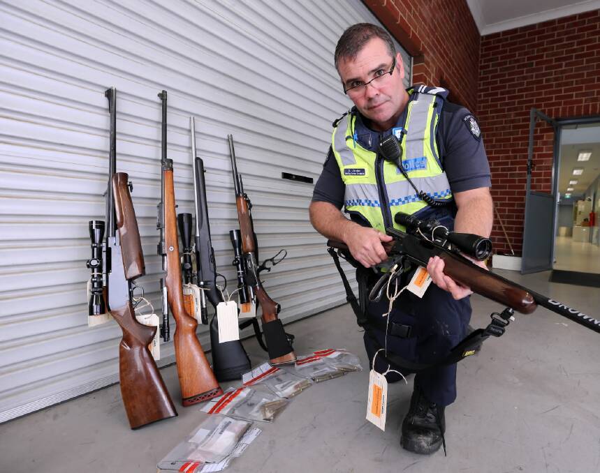 Myrtleford policeman Dave Jenkins with guns and ammunition seized from deer hunters at the weekend. Picture: PETER MERKESTEYN