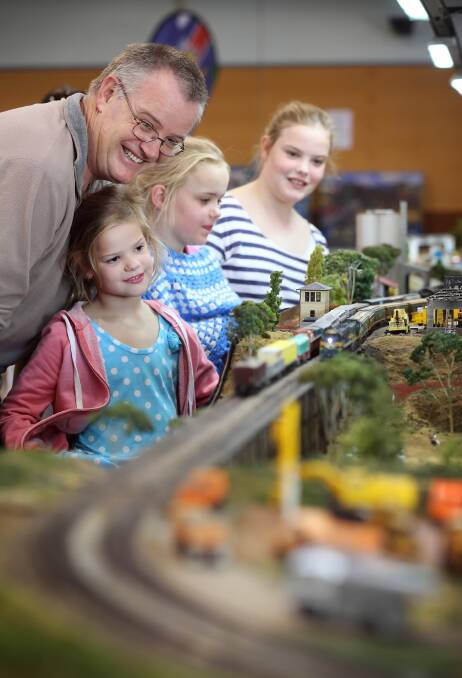 Lee Weissel and daughters Sienna, Skylah and Elle admire the Cockroach Valley exhibit assembled by the Chewton Railway Modelling Group for the annual show at the Mirambeena centre. Picture: JOHN RUSSELL