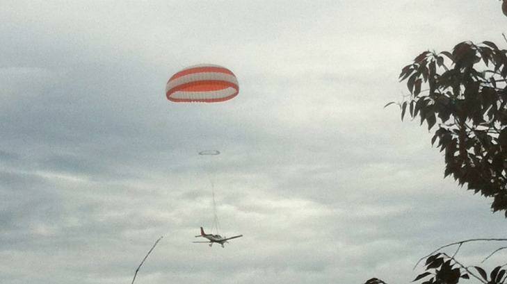 The stricken aircraft floats to earth under its parachute. Photo: Claire Hills