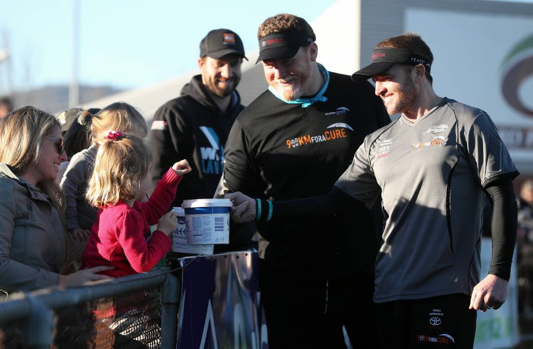 Melanoma survivors Andrew Rust and Jay Allen welcome a donation from Hailey Butler and her niece Clodagh Way, 4, at Saturday’s North Albury and Lavington game at Bunton Park. Picture: JOHN RUSSELL
