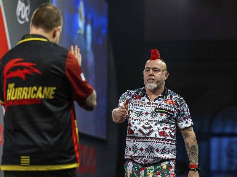 Peter Wright's (r) darts world title defence is over after losing to Kim Huybrechts (l) in London. (AP PHOTO)