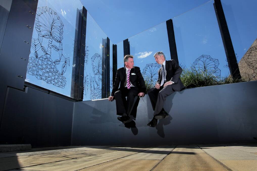 Mayor Kevin Mack and Greg Aplin discuss the anti-graffiti art work which has been installed on perspex barriers on the Kenilworth Street footbridge. It is hoped the art work will deter graffiti and vandalism. Picture: DAVID THORPE